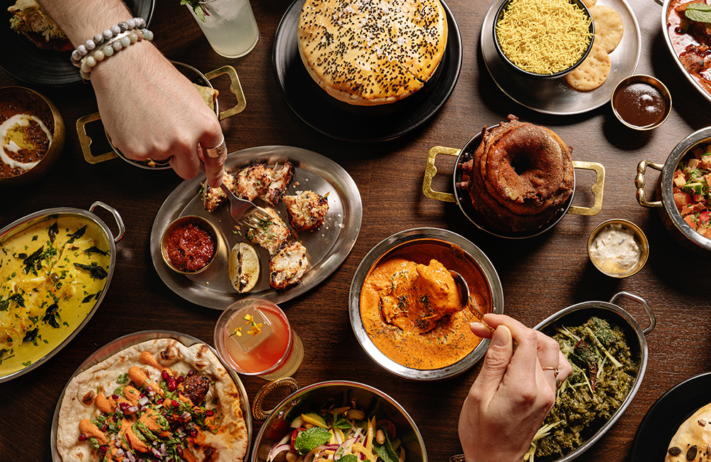 Birds eye view of hungry hands reaching towards a selection of tasty treats.